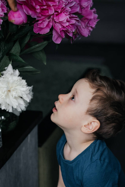 child with a bouquet of peonies - Fotó, kép