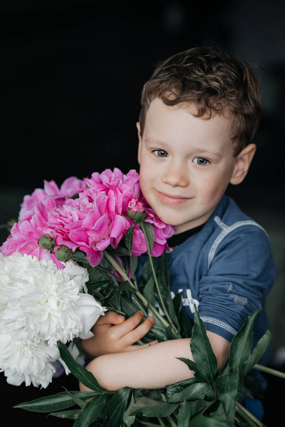 child with a bouquet of peonies - Foto, Imagen