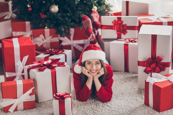 Portrait of her she nice attractive pretty charming cheerful cheery girl lying on carpet floor among pile stack giftboxes christmastime sale in light decorated house interior indoor - Foto, afbeelding