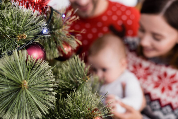 árbol de Navidad decorado cerca de la familia borrosa en el fondo - Foto, Imagen