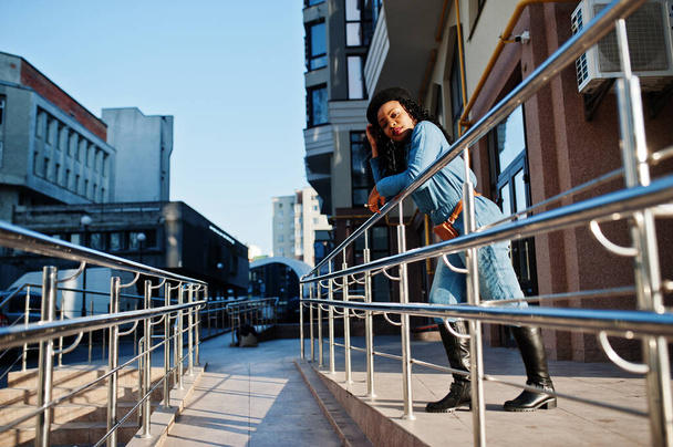 Stylish fashionable african american women in jeans wear and black beret against modern building. - Fotoğraf, Görsel