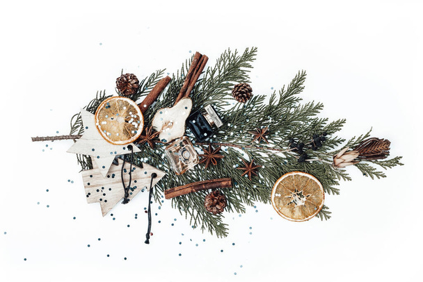 Composição de Natal com ramo de abeto, brinquedos de madeira de Ano Novo, garrafas de perfume, frutos secos e plantas - Foto, Imagem