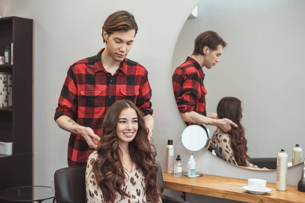 Stylista fryzjer stylizacja długie włosy dla pięknej azjatyckiej młodej kobiety w salonie piękności, moment pracy - Zdjęcie, obraz