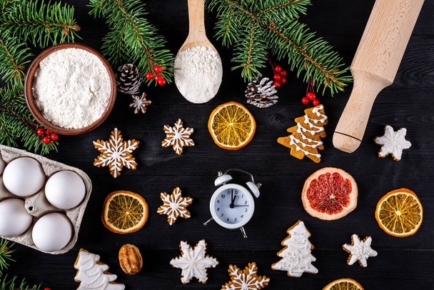 Christmas cookies and ingredients for their preparation on a wooden table top view. Xmas background. - Fotografie, Obrázek