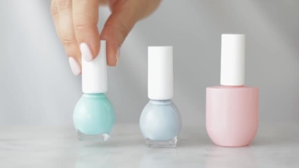 Natural beauty product scene, female hands and nailpolish bottles for french manicure, colourful pastel nail polish on marble table, make-up and cosmetic brand - Footage, Video