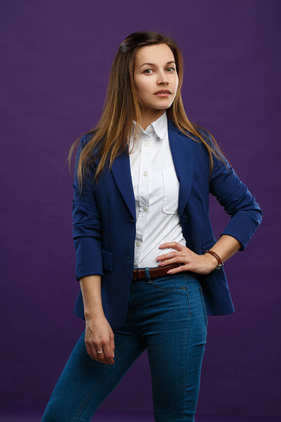 Πορτρέτο ενός νεαρού κοριτσιού με κοστούμι επιχείρησης απομονωμένο σε μωβ φόντο. - Φωτογραφία, εικόνα