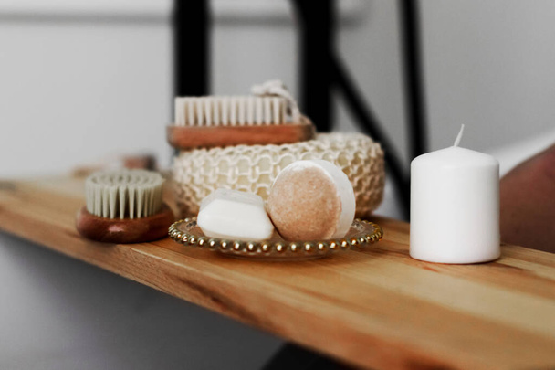 аксессуары для ванной. мыло, мочалка, чистящая щетка, пена для ванны на деревянной доске в ванной - Фото, изображение
