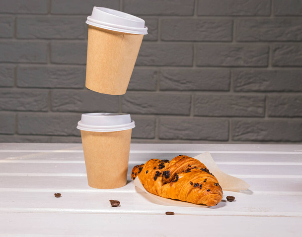 Take away coffee, fresh croissant and coffe beans on wooden background, Copy Space - Photo, Image