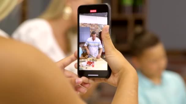 Junge Food-Bloggerin filmt am Telefon das Kochen von Familienessen. Hausmannskost - Filmmaterial, Video