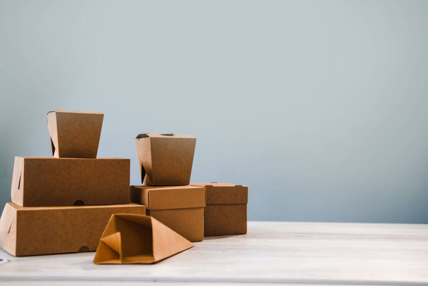 Different types of brown cardboard packaging. For fast food, folding, large and small. The concept of production and design of paper products. Place for text. Selective focus. - Photo, Image