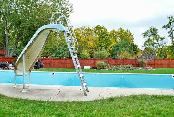 piscina patio trasero con tobogán de la piscina vaciado apagado para el invierno - Foto, Imagen