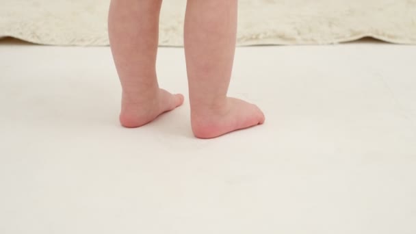 Kleine meisjes voeten op de witte loper close-up. Langzame beweging. - Video