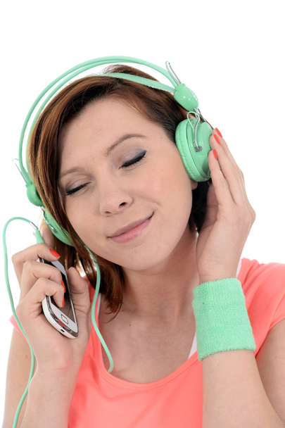Młoda atrakcyjna kobieta z telefonów komórkowych i słuchawki, słuchanie muzyki - Zdjęcie, obraz