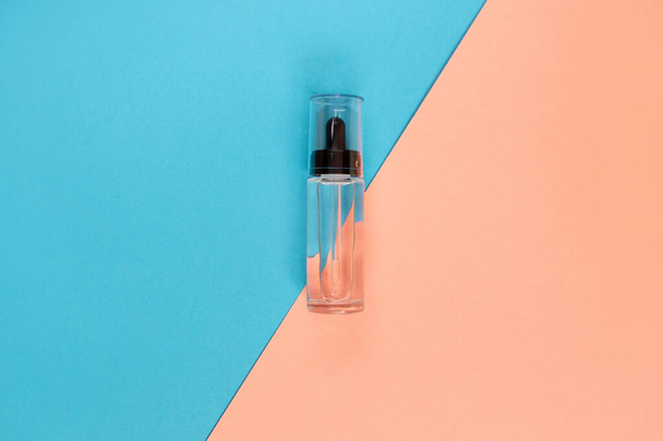 Botella de vidrio gotero Mock-Up. pipeta osmética sobre fondo azul y rosa. Maqueta de marca de productos cosméticos SPA. Piso de estilo minimalista laico. - Foto, imagen