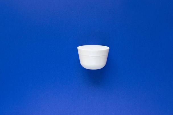 Jar for liquid, cream, gel, lotion. osmetic jar on blue background. SPA cosmetic product branding mockup. Flat lay minimalist style. - Photo, Image