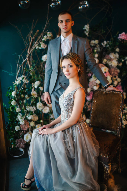 Wedding married couple posing against the background of winter decor. Background of roses and branches in the New Year's style. Selected focus. Blurred background - Fotografie, Obrázek