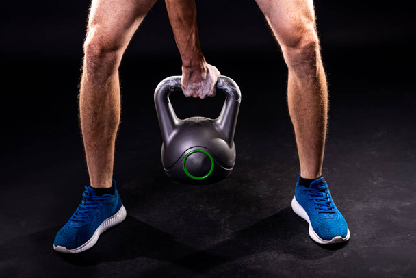 Sports man holding a kettlebell, close-up. Fitness kettlebell. - Photo, image