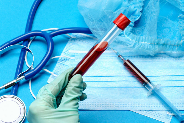 lab technician assistant or doctor holding a blood sample in test tube - Fotoğraf, Görsel