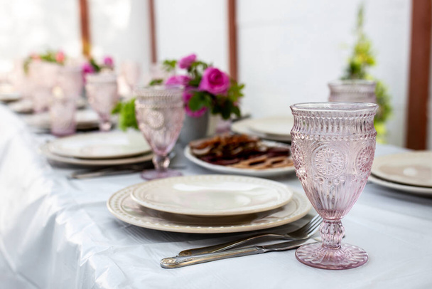 Asztalbeállítás borospoharakkal, evőeszközökkel és tányérokkal - Fotó, kép