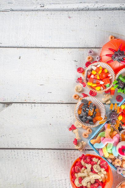 Egy halloweeni édességet és cukorkát. Különböző gyerekek kezeli Halloween - cukorka, gabonapehely reggeli, édességek, iskolai uzsonnás doboz és vödör, lapos másolás tér felülnézet - Fotó, kép