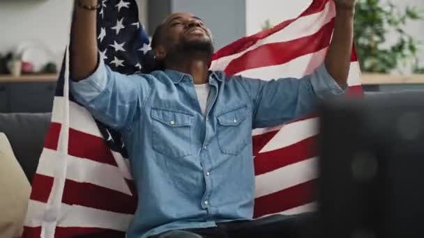 Video di un uomo estremamente felice che guarda la TV con bandiera USA. Girato con telecamera ad elio rosso in 8K. - Filmati, video