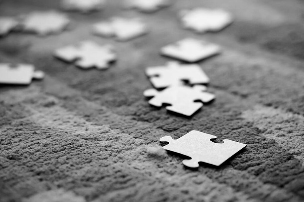 A closeup of various upside-down puzzle pieces placed on a fluffy carpet - Фото, зображення