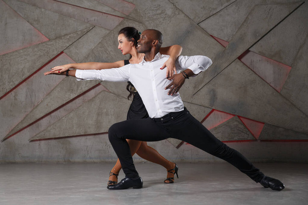 Elegant black man and white girl dancing. - Фото, зображення
