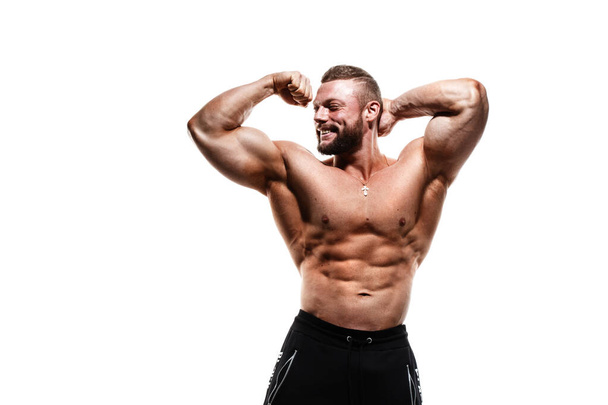 Smiling athletic caucasian man with a naked torso demonstrates biceps isolated on a white background. - Foto, immagini