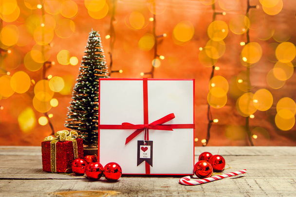 Caja de regalo con decoraciones navideñas y luces bokeh en una mesa de madera - Foto, imagen