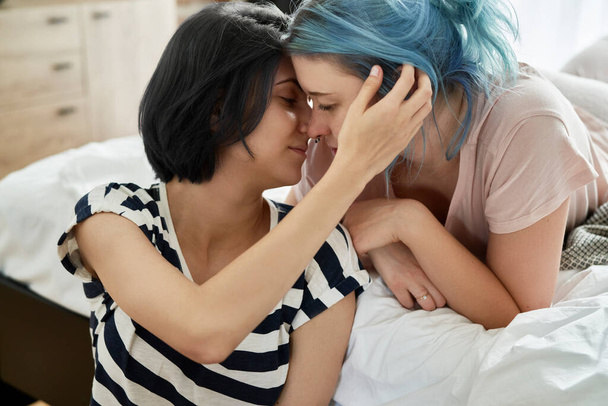 Romantyczna lesbijska para całująca się z miłością w sypialni                                - Zdjęcie, obraz