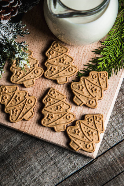 Leite fresco e biscoitos de Natal com decorações de Natal em uma mesa de madeira - Foto, Imagem