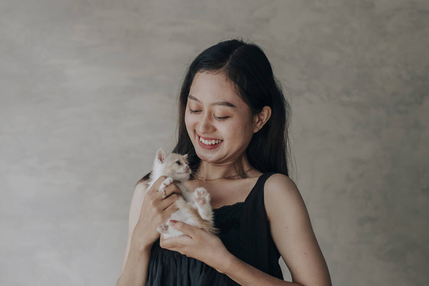 Young Asian woman holding and playing with her cute kitten cat with lovely moment - Foto, Imagen