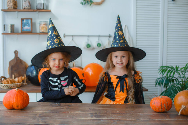 deux petites filles en costume de sorcière pour Halloween effrayer, dans la cuisine - Photo, image