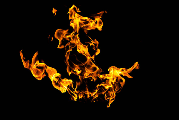 Feuerflammen auf schwarzem Hintergrund isoliert. Brennendes Gas oder Benzin verbrennt mit Feuer und Flammen. Flammende brennende Funken aus nächster Nähe, Brandmuster. Höllenfeuer im Dunkeln mit Kopierraum - Foto, Bild