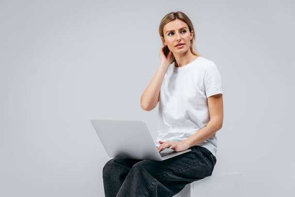 Modern Girl in white t-shirt with laptop in studio. Free creativity - Fotoğraf, Görsel