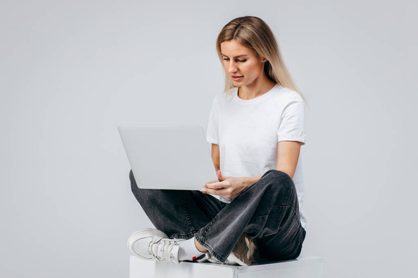 Modern Girl in white t-shirt with laptop in studio. Free creativity - Fotó, kép