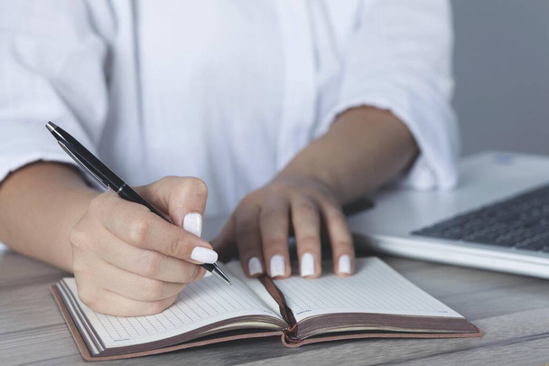 woman hand pen with notepad on the working desk - Φωτογραφία, εικόνα