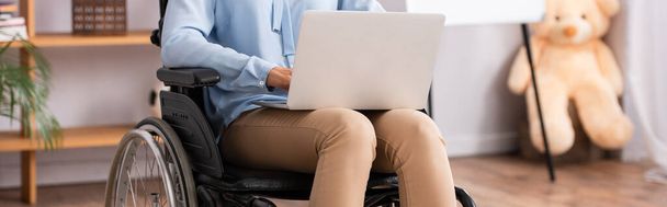 Vista ritagliata di psicologo disabili utilizzando laptop con ufficio offuscato su sfondo, banner - Foto, immagini