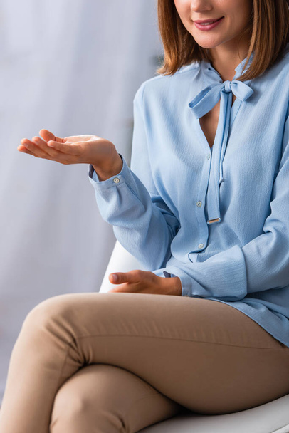 Vista recortada del gesto de la psicóloga femenina mientras está sentada en la silla en la oficina - Foto, imagen