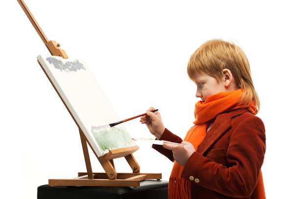 Маленький рыжий мальчик рисует на мольберте
 - Фото, изображение