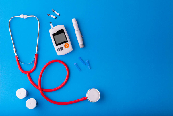 World diabetes day, Free Glucose Monitors on blue background with red Stethoscope put on blue on  top view Healthcare and medical concept - Foto, Imagen