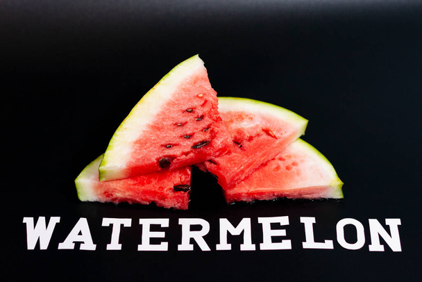 Watermelon slices are arranged in a slide-like overlap. Theres an inscription at the bottom. - Photo, Image