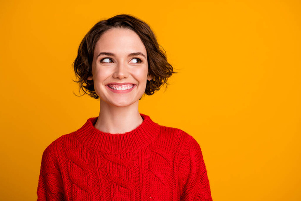 Closeup photo of cheerful pretty lady good mood short bob hairdo celebrate look side empty space funny expression wear casual red knitted sweater isolated bright yellow color background - Zdjęcie, obraz