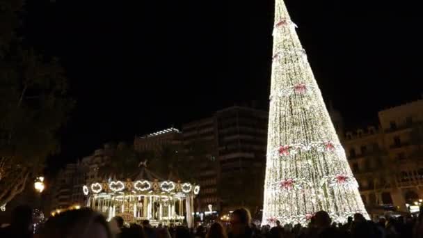 Décembre 2019. Valencia, Espagne. Vidéo de la Plaza del Ayuntamiento de Valencia dans laquelle vous pouvez voir comment la roue tourne et le sapin de Noël situé sur la place brille - Séquence, vidéo