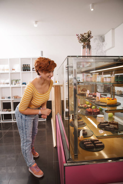 Pionowe ujęcie kobiecego klienta robiącego zakupy w sklepie cukierniczym - Zdjęcie, obraz