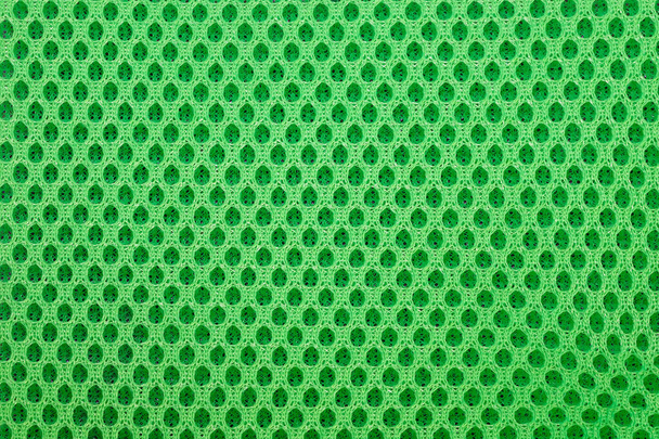 πράσινο φόντο ειδικό πλέγμα υφάσματος. Πολυεστερικό πλέγμα με αφρώδες ελαστικό για την κατασκευή σακιδίων. Επένδυση πλέγματος με αφρό για το εσωτερικό σάκου ή ρούχων. - Φωτογραφία, εικόνα