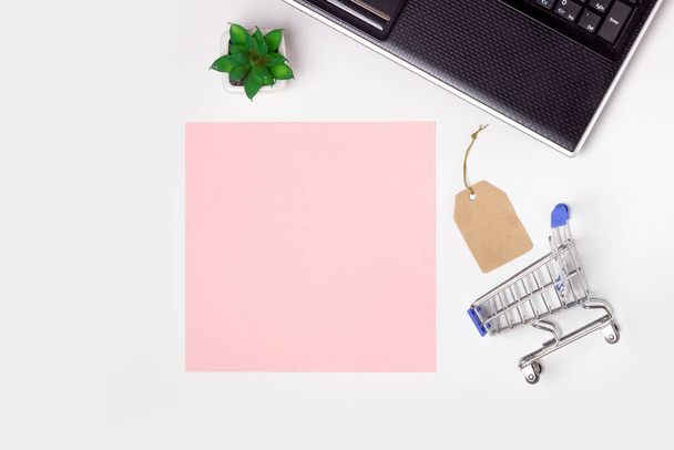 Black Friday. Laptop, note book and shopping trolley on a white background. Online shopping concept - Фото, изображение