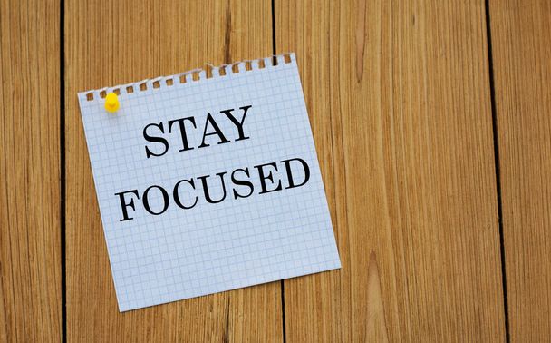 STAY FOCUSED - words on white paper attached to a wooden board. Business and education concept. - Photo, Image