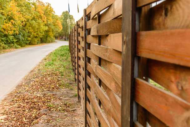 Egy régi kerítés fa deszkák körül telek található, közel az úthoz - Fotó, kép