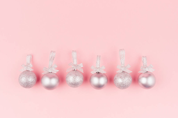 Festive bright new year background - glitter silver balls in row as decorative border on soft light pastel pink background. - Zdjęcie, obraz